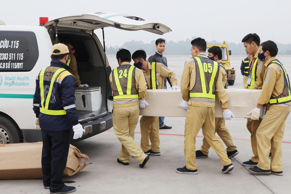 Lực lượng chức năng đưa thi thể các nạn nhân, chuẩn bị bàn giao cho các địa phương để vận chuyển từ sân bay quốc tế Nội Bài về quê nhà. (Ảnh: Lâm Khánh/TTXVN)