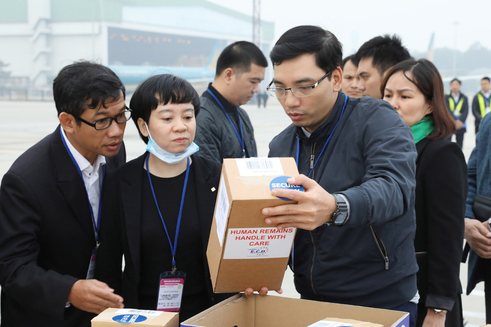 Lực lượng chức năng kiểm tra tro cốt của các nạn nhân, chuẩn bị bàn giao cho các địa phương để vận chuyển từ sân bay quốc tế Nội Bài về quê nhà. (Ảnh: Lâm Khánh/TTXVN)