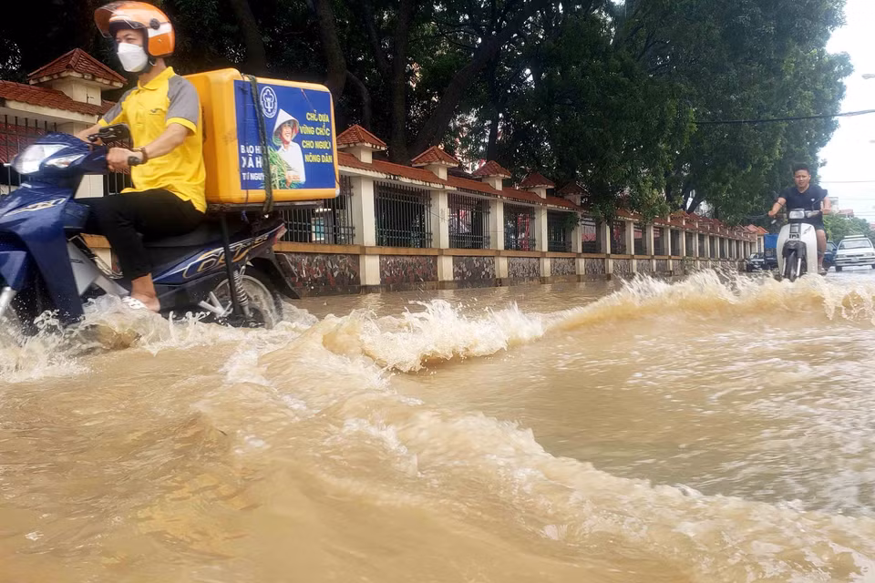 Người dân vất vả di chuyển trên đường Mê Linh, thành phố Vĩnh Yên. (Ảnh: Hoàng Hùng/TTXVN)