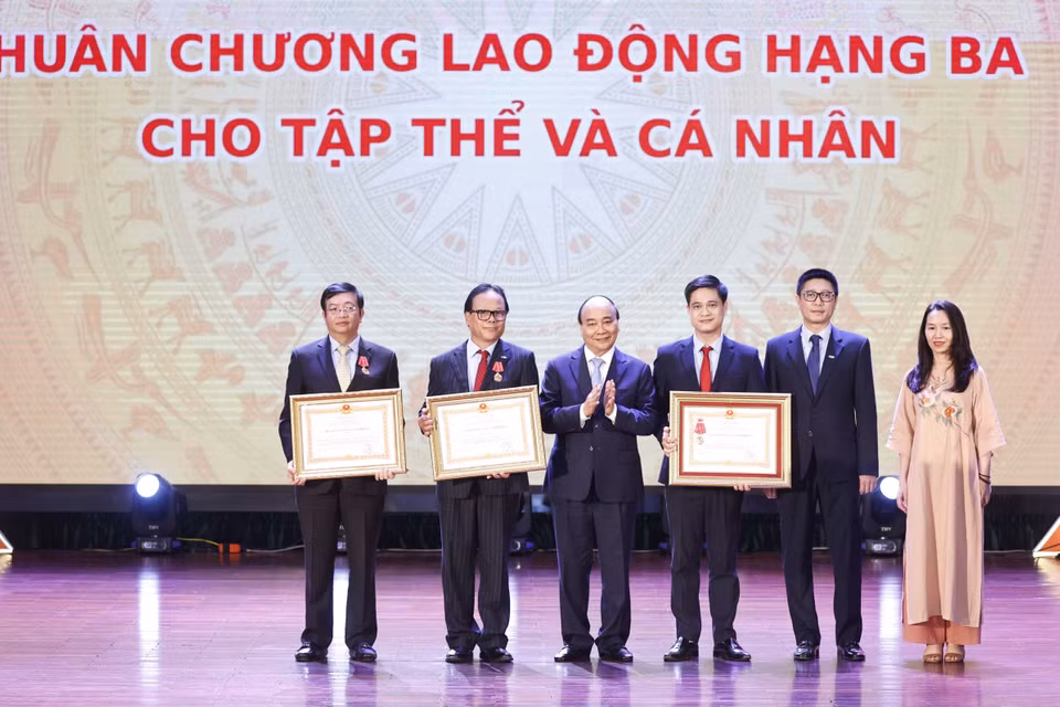 Chủ tịch nước Nguyễn Xuân Phúc trao tặng Huân chương Lao động hạng Ba cho tập thể và các nhân của Trường Đại học Kinh tế Quốc dân. (Ảnh: Thống Nhất/TTXVN)