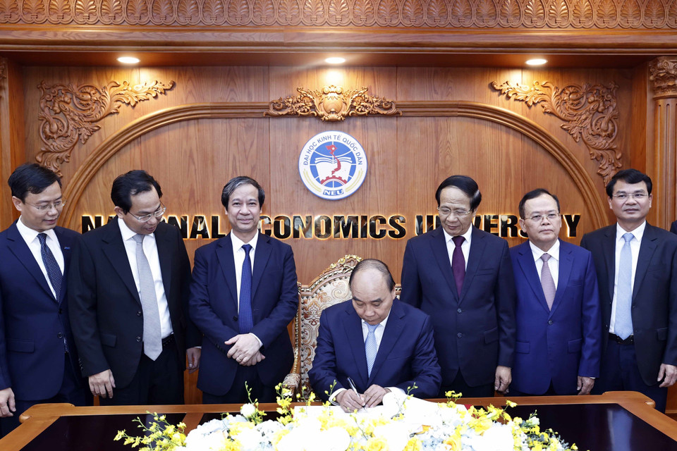 Chủ tịch nước Nguyễn Xuân Phúc viết lưu bút tại phòng truyền thống Trường Đại học Kinh tế Quốc dân. (Ảnh: Thống Nhất/TTXVN)