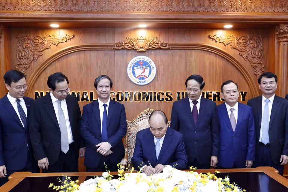 Chủ tịch nước Nguyễn Xuân Phúc viết lưu bút tại phòng truyền thống Trường Đại học Kinh tế Quốc dân. (Ảnh: Thống Nhất/TTXVN)