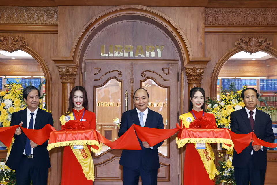 Chủ tịch nước Nguyễn Xuân Phúc và các đại biểu cắt băng khánh thành thư viện điện tử dùng chung cho 45 trường đại học. (Ảnh: Thống Nhất/TTXVN)