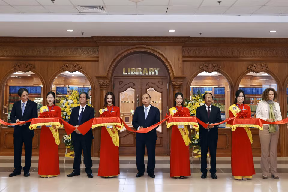 Chủ tịch nước Nguyễn Xuân Phúc và các đại biểu cắt băng khánh thành thư viện điện tử dùng chung cho 45 trường đại học. (Ảnh: Thống Nhất/TTXVN)