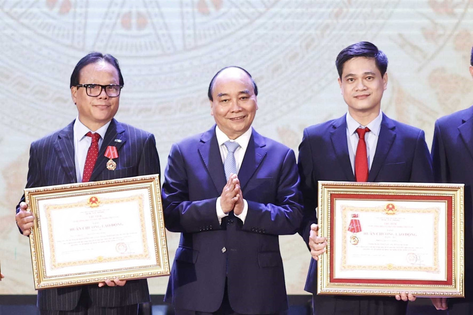 Chủ tịch nước Nguyễn Xuân Phúc trao tặng Huân chương lao động hạng Ba cho tập thể và các nhân Trường Đại học Kinh tế Quốc dân. (Ảnh: Thống Nhất/TTXVN)