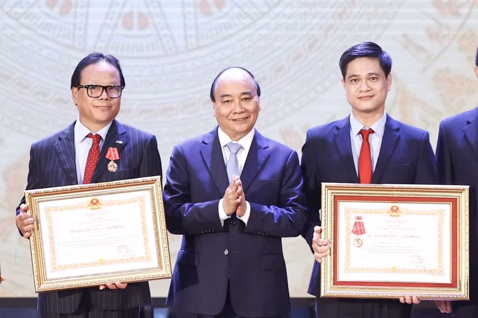 Chủ tịch nước Nguyễn Xuân Phúc trao tặng Huân chương lao động hạng Ba cho tập thể và các nhân Trường Đại học Kinh tế Quốc dân. (Ảnh: Thống Nhất/TTXVN)