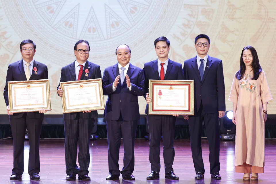 Chủ tịch nước Nguyễn Xuân Phúc trao tặng Huân chương Lao động hạng Ba cho tập thể và các nhân Trường Đại học Kinh tế Quốc dân. (Ảnh: Thống Nhất/TTXVN)