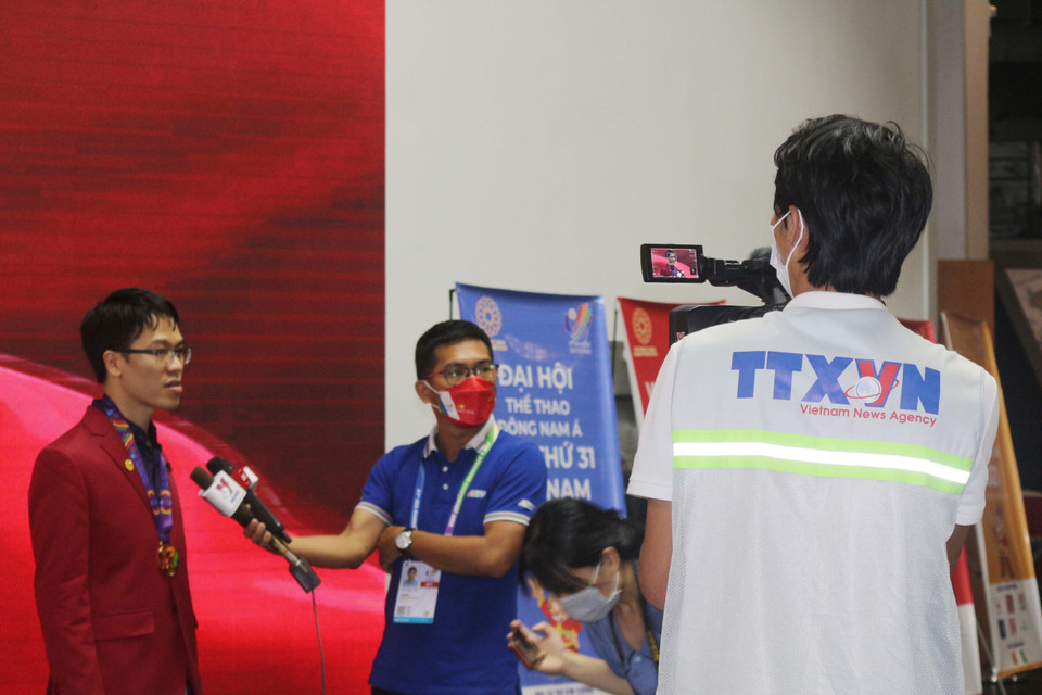 Phóng viên TTXVN phỏng vấn siêu đại kiện tướng cờ vua Việt Nam Lê Quang Liêm tại SEA Games 31. (Ảnh: Thanh Vân/TTXVN)