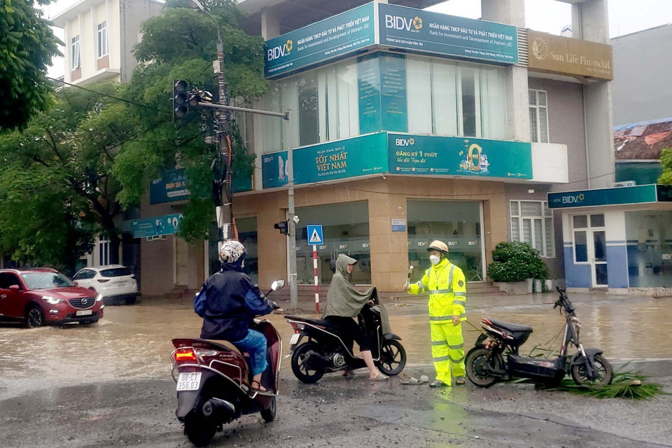 Người dân lúng túng tìm cách di chuyển qua những tuyến đường bị ngập nước tại thành phố Vĩnh Yên. (Ảnh: Hoàng Hùng/TTXVN)