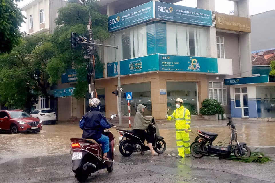 Người dân lúng túng tìm cách di chuyển qua những tuyến đường bị ngập nước tại thành phố Vĩnh Yên. (Ảnh: Hoàng Hùng/TTXVN)