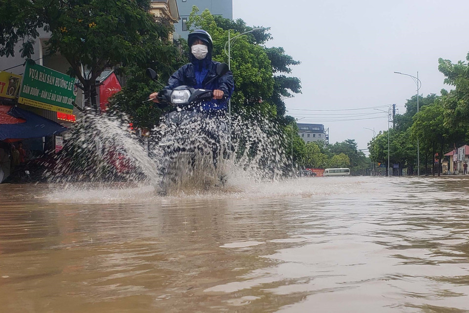 Người dân vất vả di chuyển trên đường Mê Linh, thành phố Vĩnh Yên. (Ảnh: Hoàng Hùng/TTXVN)
