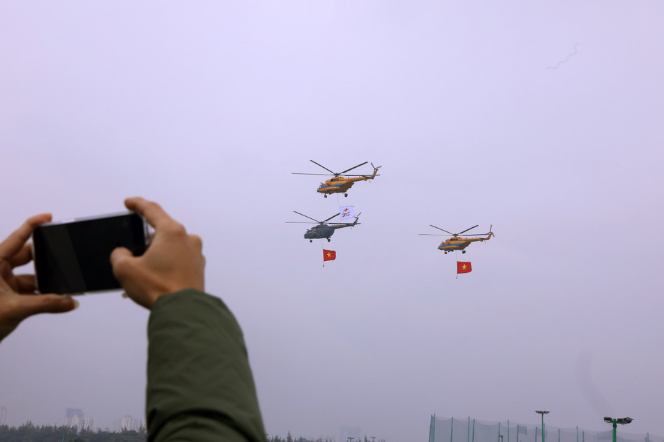 Biên đội trực thăng dòng Mi thuộc Trung đoàn không quân 916 cùng cờ Tổ quốc và cờ hiệu Triển lãm Quân sự quốc tế Việt Nam 2022 biểu diễn trên không gian triển lãm. (Ảnh: Văn Điệp/TTXVN)