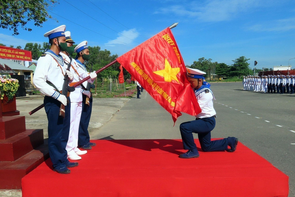 Chiến sỹ mới thực hiện nghi thức hôn lá Quân kỳ trong buổi lễ tuyên thệ chiến sỹ mới của Vùng 2 Hải quân. (Ảnh: Đoàn Mạnh Dương/TTXVN)