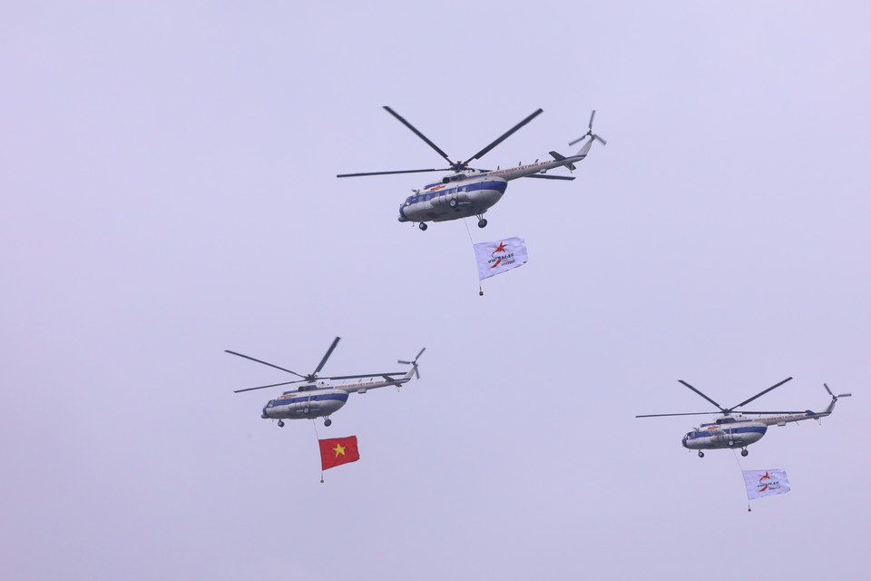 Biên đội trực thăng dòng Mi thuộc Trung đoàn không quân 916 cùng cờ Tổ quốc và cờ hiệu Triển lãm Quân sự quốc tế Việt Nam 2022 biểu diễn trên không gian triển lãm. (Ảnh: Văn Điệp/TTXVN)