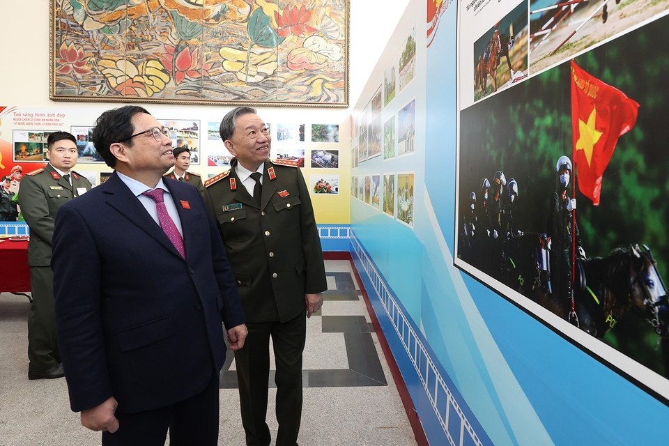 Thủ tướng Phạm Minh Chính và Đại tướng Tô Lâm, Bộ trưởng Bộ Công an xem trưng bày ảnh về các hoạt động của lực lượng Công an. (Ảnh: Dương Giang/TTXVN)