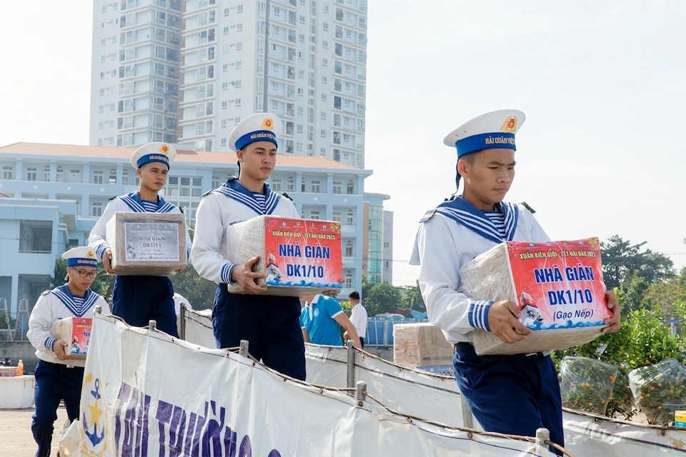 Các chiến sỹ chuyển quà Tết lên tàu. (Ảnh: Đoàn Mạnh Dương/TTXVN)