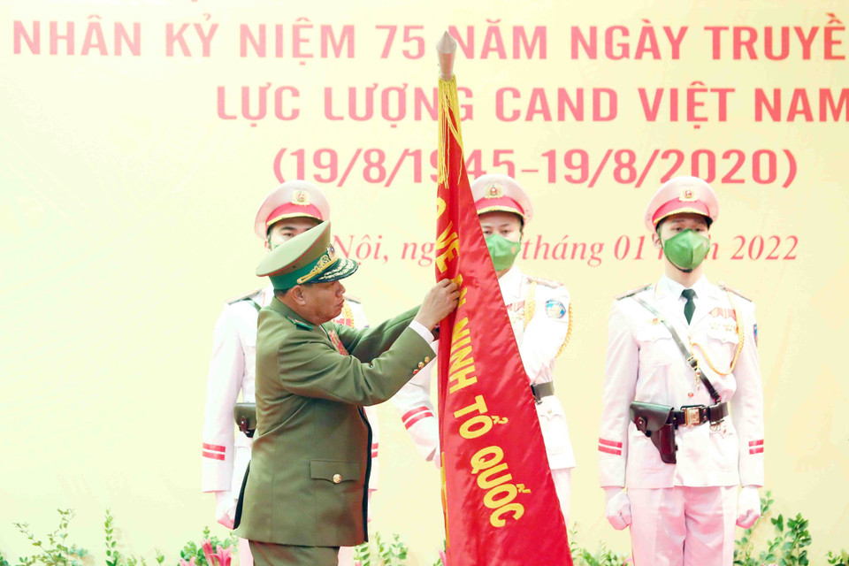 Đại tướng Vilay Lakhamphong, Bộ trưởng Bộ Công an nước Cộng hòa Dân chủ Nhân dân Lào gắn Huân chương Tự do hạng Nhất của Nhà nước CHDCND Lào lên lá cờ truyền thống của Bộ Công an nước CHXHCN Việt Nam. (Ảnh: Phạm Kiên/TTXVN)