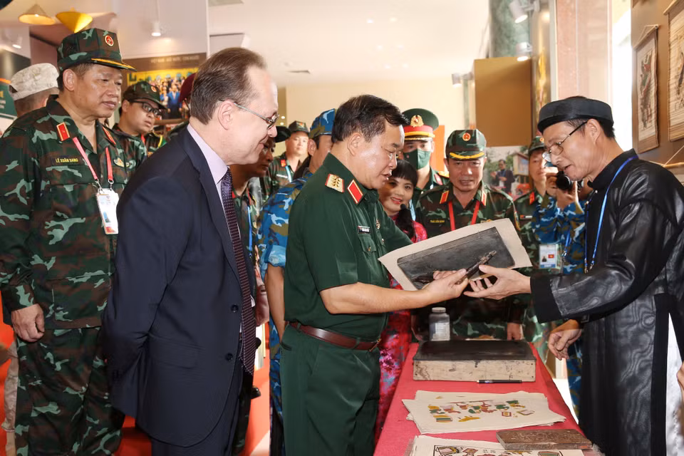 Thượng tướng Hoàng Xuân Chiến, Thứ trưởng Bộ Quốc phòng và Ngài Gennady Bezdetko, Đại sứ Đặc mệnh toàn quyền Liên bang Nga tại Việt Nam tham quan triển lãm Không gian văn hóa Việt Nam tại cuộc thi. (Ảnh: TTXVN phát)