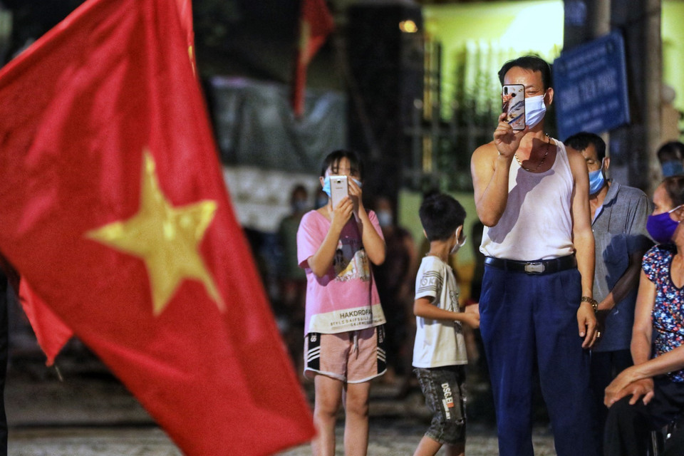 Người dân thôn Lỗ Giao háo hức chờ đợi khoảnh khắc dỡ bỏ cách ly. (Ảnh: Thành Đạt/TTXVN)