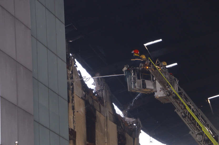 Cảnh sát Phòng cháy chữa cháy phun nước vào tầng 5 Công ty Kwong Lung-Meko để dập lửa. (Ảnh: Thanh Liêm/TTXVN)