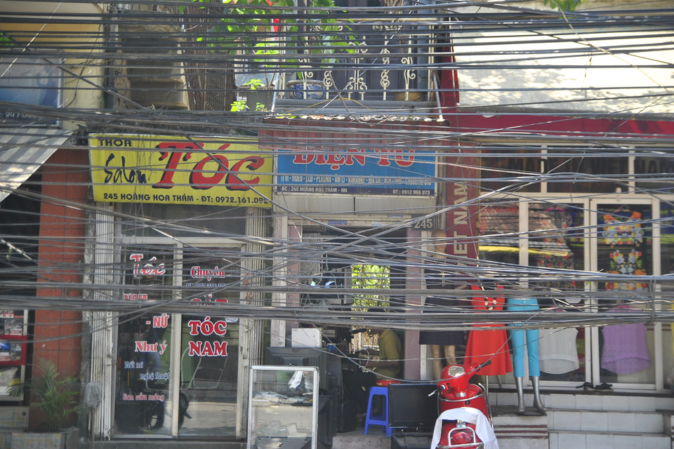 Người dân nói đùa nhau: Thế này thì có khác gì được che nắng bằng dây điện đâu. (Ảnh: Võ Phương)