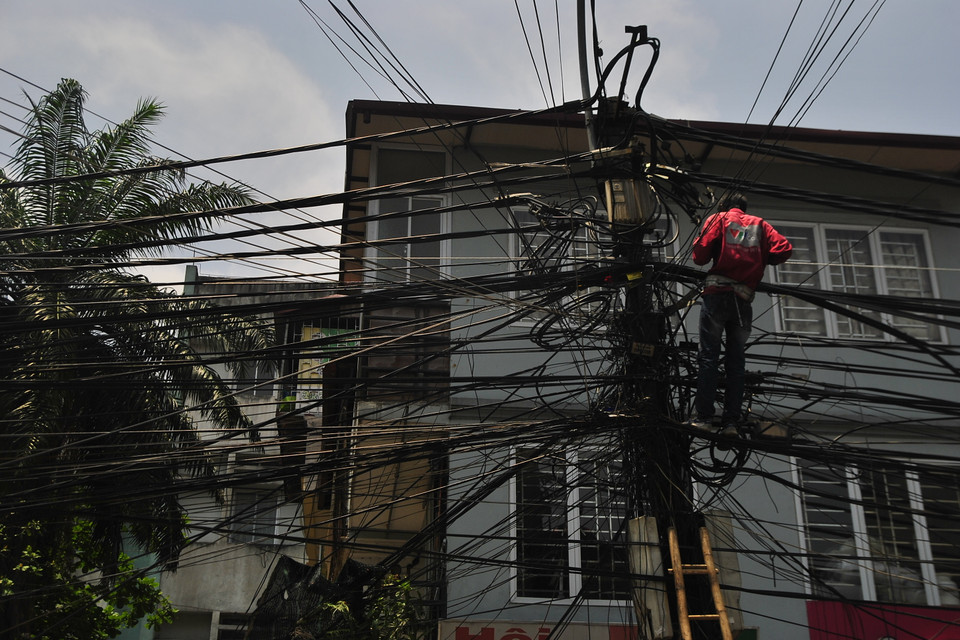 Theo phản ánh của người dân sống trên đoạn phố, vào trưa ngày 16/5, một số nhân viên kỹ thuật có tới thay mới dây truyền hình cáp tại bốt điện, từ đó đến nay, mớ dây cũ, và có thể là các dây còn sử dụng hạ thấp xuống, gây ra khung cảnh mất mỹ quan này. (Ảnh: Võ Phương/Vietnam+)