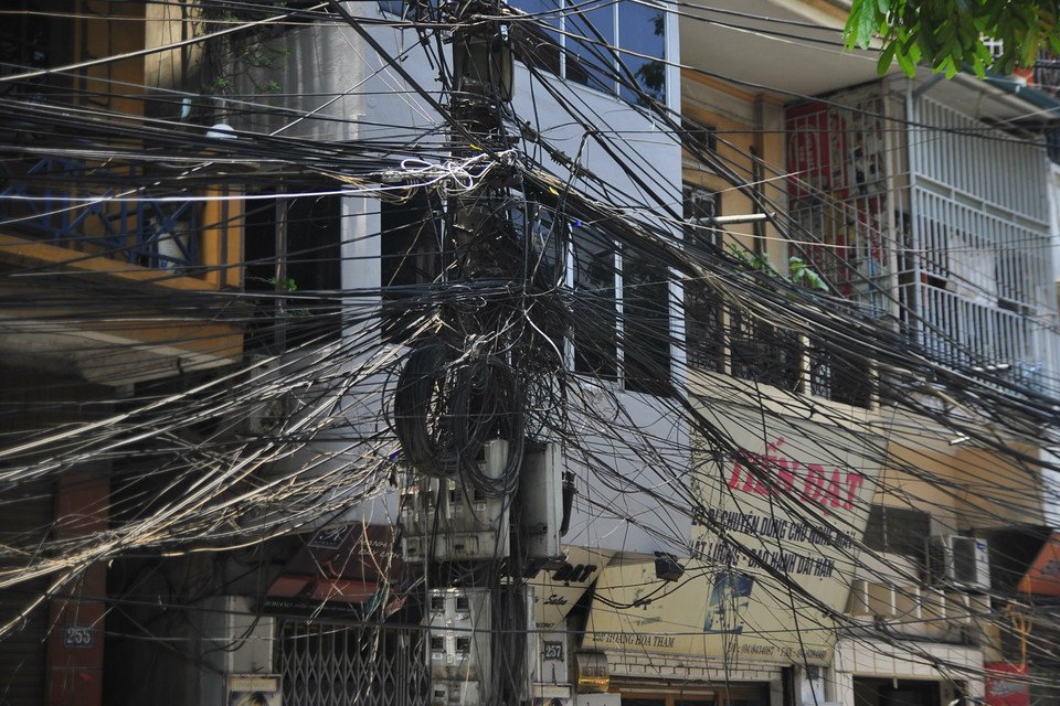 Cho tới trưa ngày 18/5, các mớ dây lằng ngoằng vẫn rũ xuống đường phố Hoàng Hoa Thám, gây khó chịu và lo lắng cho người dân. (Ảnh: Võ Phương/Vietnam+)