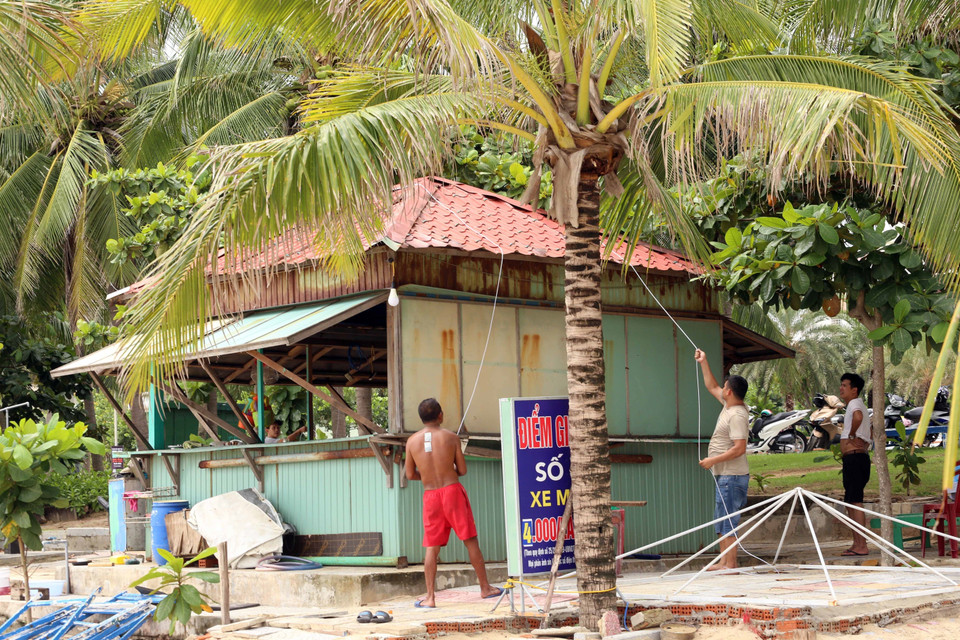 Người dân Đà Nẵng đang chằng buộc tài sản để tránh bão Noru. (Ảnh: Trần Lê Lâm/TTXVN)