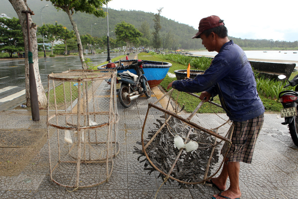 Ngư dân Đà Nẵng vận chuyển các ngư lưới cụ vào sâu đất liền để tránh bão Noru. (Ảnh: Trần Lê Lâm/TTXVN)