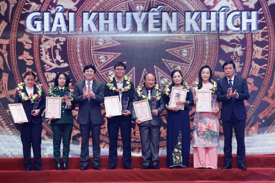 Ông Nguyễn Hạnh Phúc, Tổng Thư ký Quốc hội, Chủ nhiệm Văn phòng Quốc hội, Trưởng ban Chỉ đạo Giải và đồng chí Hồ Quang Lợi, Phó Chủ tịch Thường trực Hội Nhà báo Việt Nam trao giải Khuyến khích cho các tác giả. (Ảnh: Dương Giang/TTXVN)