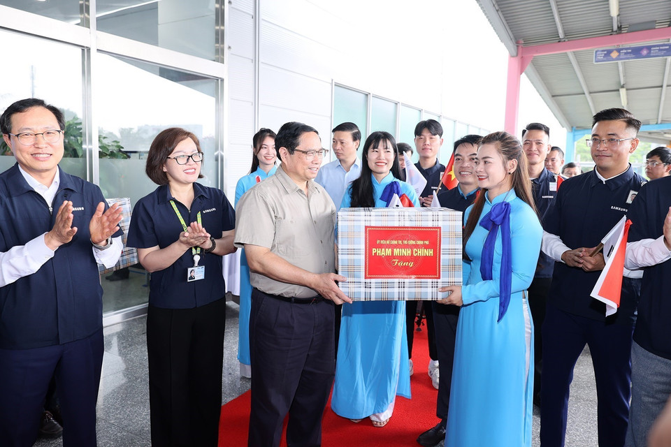 Thủ tướng Phạm Minh Chính tặng quà cho đại diện lãnh đạo, nhân viên Công ty TNHH Samsung Việt Nam. (Ảnh: Dương Giang/TTXVN)
