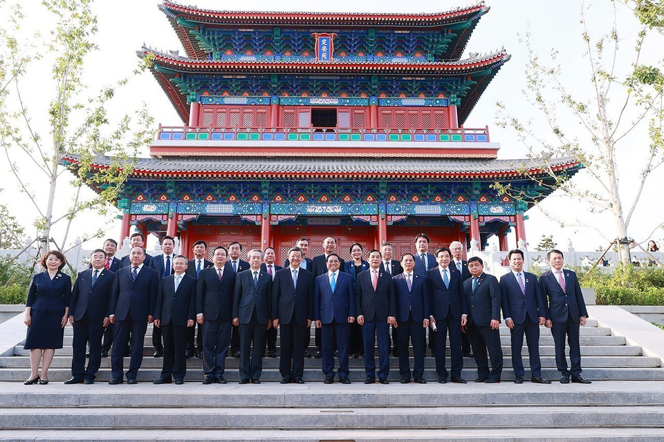 Thủ tướng Phạm Minh Chính và Bí thư Tỉnh ủy Hà Bắc Nghê Nhạc Phong cùng thành viên đoàn chụp ảnh chung tại Định An Các, Khu mới Hùng An. (Ảnh: Dương Giang/TTXVN)