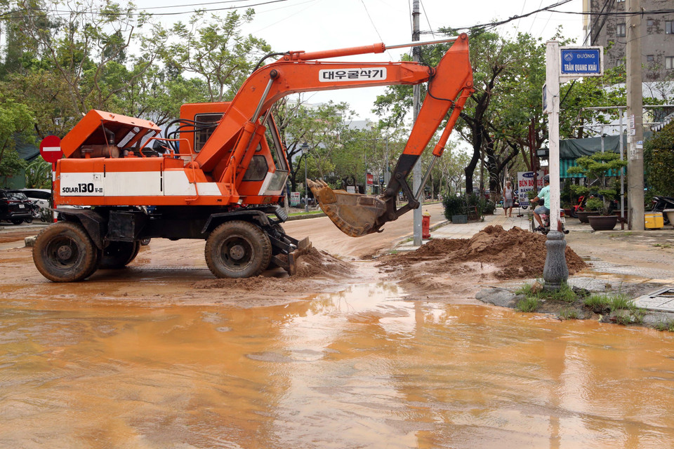Các phương tiện cơ giới được huy động để dọn vệ sinh trên các tuyến đường sau khi bị ngập nước. (Ảnh: Trần Lê Lâm/TTXVN)