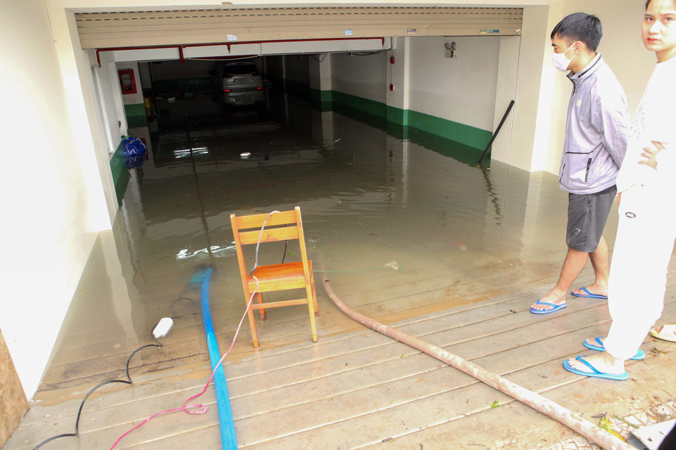 Người dân chủ động thuê máy bơm về hút nước ngập trong các tầng hầm tòa nhà ra ngoài. (Ảnh: Trần Lê Lâm/TTXVN)
