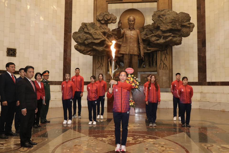 Vận động viên điền kinh Nguyễn Thị Oanh cùng đoàn vận động viên tiêu biểu chuẩn bị nghi thức rước đuốc từ Bảo tàng Hồ Chí Minh. (Ảnh: Minh Quyết/TTXVN)