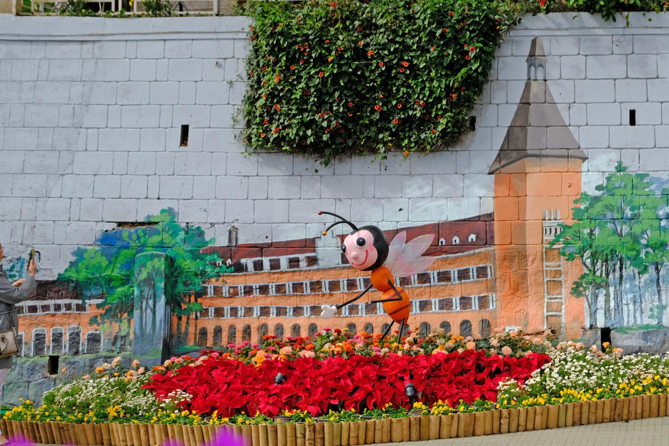 Sự kết hợp độc đáo giữa tranh tường với hình ảnh kiến trúc nổi tiếng của Đà Lạt và muôn sắc hoa Đà Lạt hấp dẫn không ít du khách. (Ảnh: Nguyễn Dũng/TTXVN)