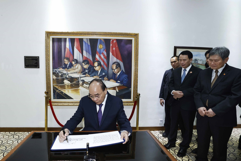 Chủ tịch nước Nguyễn Xuân Phúc viết lưu bút tại trụ sở Ban Thư ký ASEAN. (Ảnh: Thống Nhất/TTXVN)