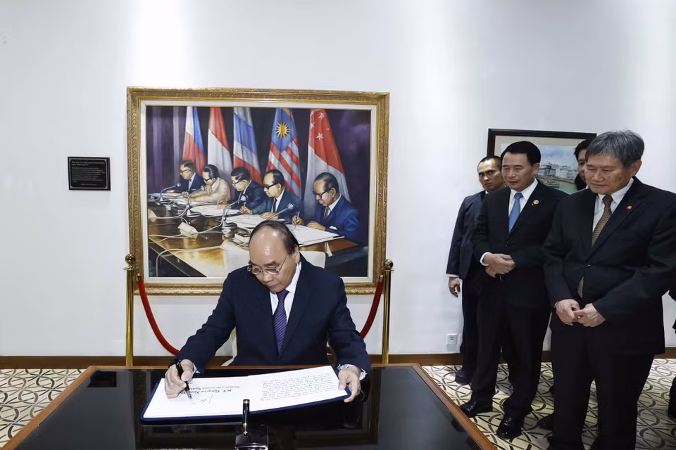 Chủ tịch nước Nguyễn Xuân Phúc viết lưu bút tại trụ sở Ban Thư ký ASEAN. (Ảnh: Thống Nhất/TTXVN)