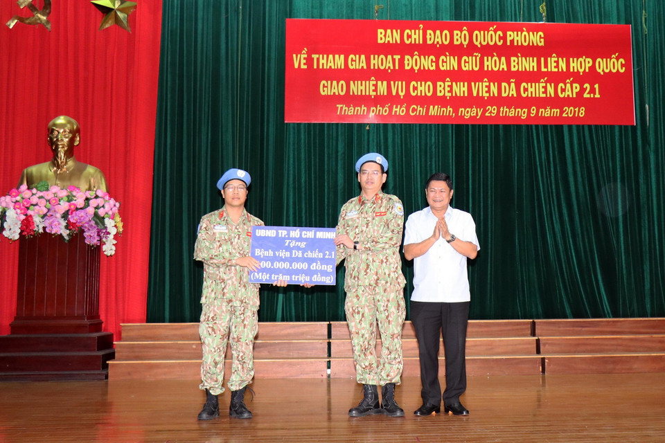 Ông Huỳnh Cách Mạng, Phó Chủ tịch UBND Thành phố trao quà tặng của UBND Thành phố động viên Bệnh viện dã chiến cấp 2 số 1 trước ngày xuất quân. (Ảnh: Xuân Khu/TTXVN)