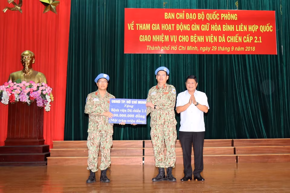 Ông Huỳnh Cách Mạng, Phó Chủ tịch UBND Thành phố trao quà tặng của UBND Thành phố động viên Bệnh viện dã chiến cấp 2 số 1 trước ngày xuất quân. (Ảnh: Xuân Khu/TTXVN)