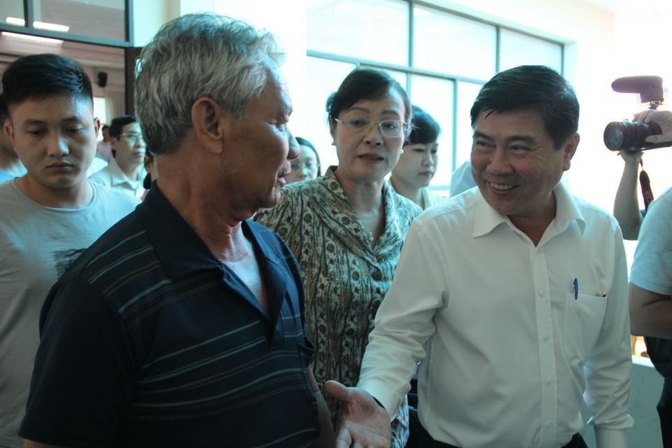 Ông Nguyễn Thành Phong, Chủ tịch Ủy ban nhân dân Thành phố Hồ Chí Minh trao đổi với người dân Thủ Thiêm sau buổi gặp gỡ. (Ảnh: Xuân Dự/TTXVN)