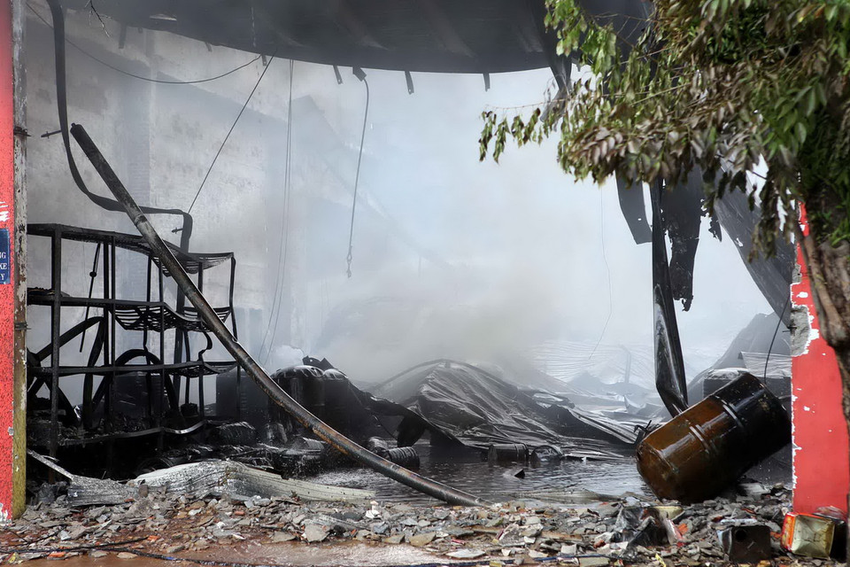 Vụ cháy được khống chế và đang tiếp tục được phun nước dập tắt không để bùng phát trở lại. (Ảnh: Lê Lâm/Vietnam+)