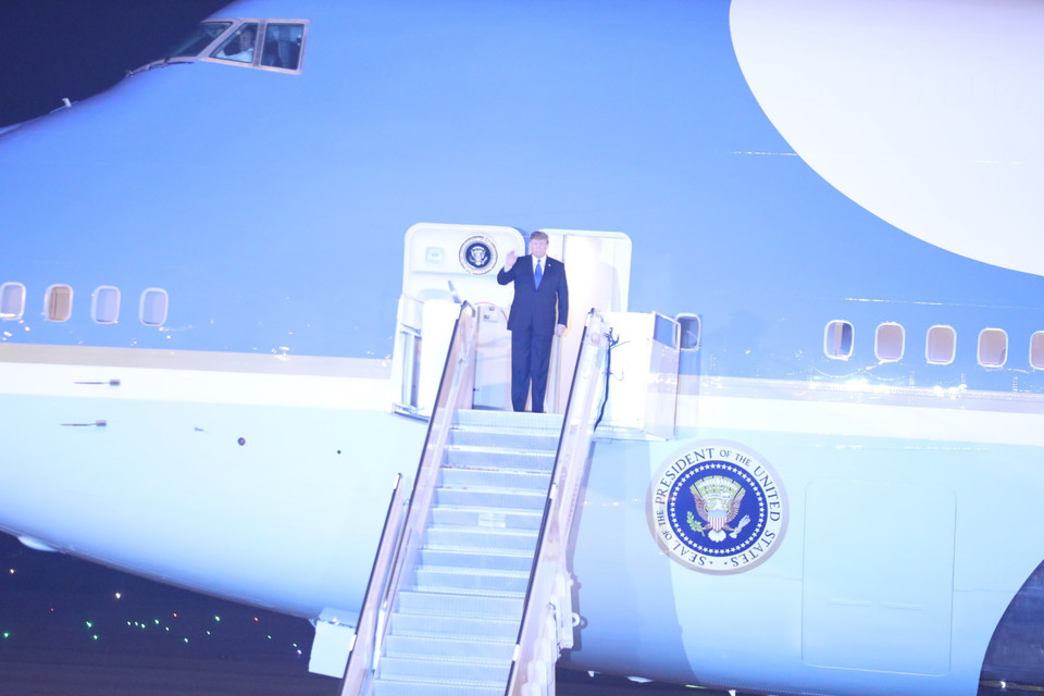 Tổng thống Mỹ Donald Trump xuất hiện ở cửa máy bay, vẫy chào các đại biểu Việt Nam và Mỹ ra đón tại sân bay quốc tế Nội Bài. (Ảnh: Phương Hoa/TTXVN)