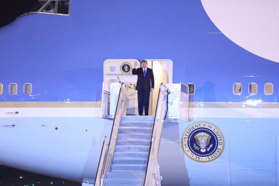 Tổng thống Mỹ Donald Trump xuất hiện ở cửa máy bay, vẫy chào các đại biểu Việt Nam và Mỹ ra đón tại sân bay quốc tế Nội Bài. (Ảnh: Phương Hoa/TTXVN)