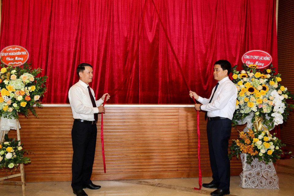 Tổng Giám đốc Thông tấn xã Việt Nam Nguyễn Đức Lợi và Chủ tịch Ủy ban Nhân dân thành phố Hà Nội Nguyễn Đức Chung kéo băng khai trương Trung tâm Truyền hình Thông tấn. (Ảnh: Dương Giang/TTXVN)