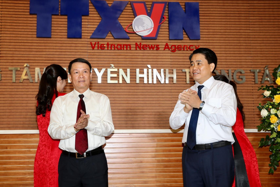 Tổng Giám đốc Thông tấn xã Việt Nam Nguyễn Đức Lợi và Chủ tịch Ủy ban Nhân dân thành phố Hà Nội Nguyễn Đức Chung kéo băng khai trương Trung tâm Truyền hình Thông tấn. (Ảnh: Dương Giang/TTXVN)