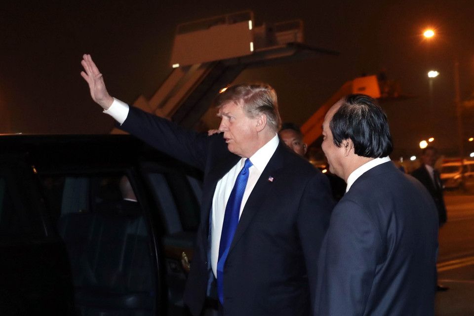 Tổng thống Mỹ Donald Trump vẫy chào các đại biểu và người dân Hà Nội ra đón tại sân bay quốc tế Nội Bài trước khi lên chiếc xe The Beast di chuyển về khách sạn Marriott JW (ảnh chụp lúc 21 giờ 7 phút). (Ảnh: Trọng Đức/TTXVN)