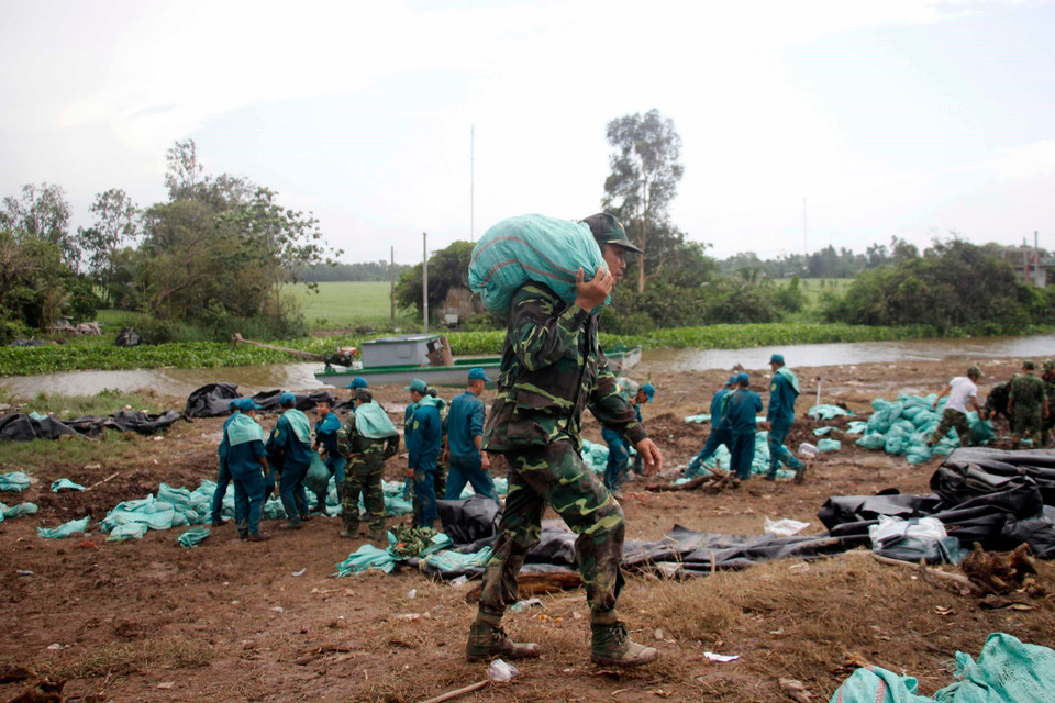 Tỉnh Cà Mau đang tích cực huy động mọi nguồn lực nhằm bảo vệ đoạn đê xung yếu trước nguy cơ bị vỡ. (Ảnh: Huỳnh Thế Anh/TTXVN)