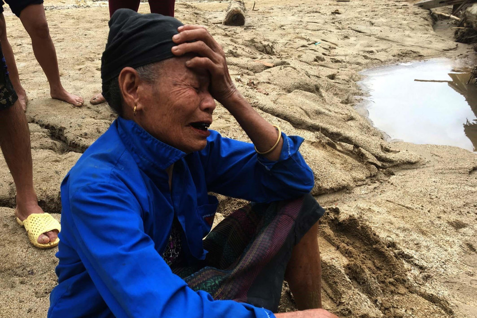 Người dân ra bờ suối mong người thân trở về sau trận lũ dữ. (Ảnh: Trịnh Duy Hưng/TTXVN)
