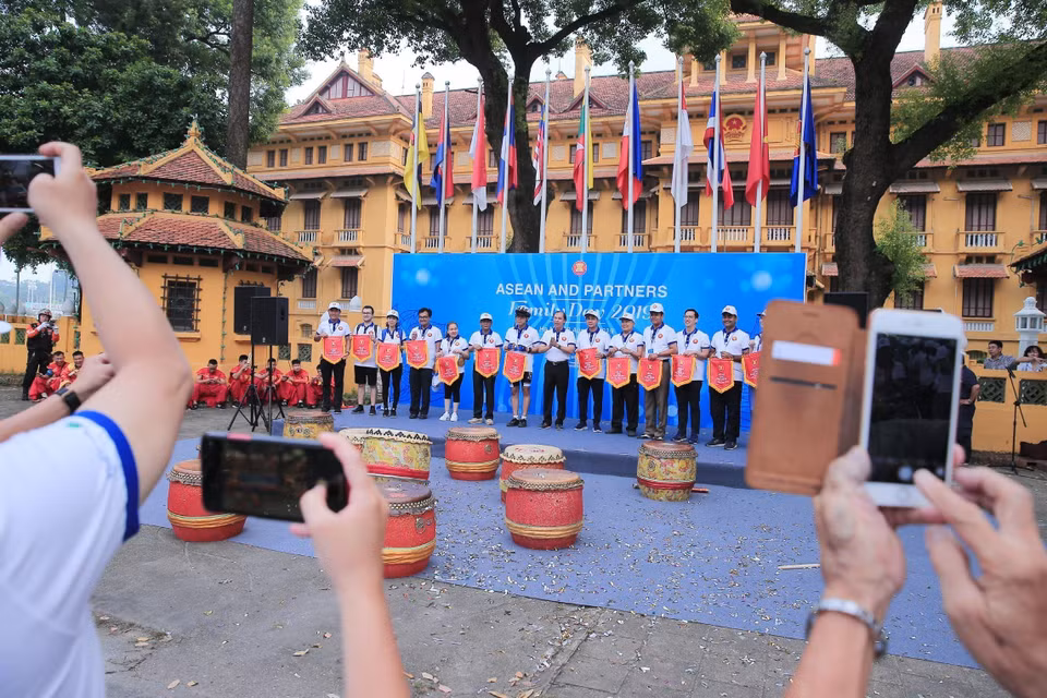  Thứ trưởng Bộ Ngoại giao Nguyễn Quốc Dũng trao cờ kỷ niệm cho các đại diện đại sứ quán các nước và các đối tác của ASEAN. (Ảnh: Lâm Khánh/TTXVN)